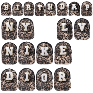 Detail of leopard print baseball caps with assorted embroidered letter patches in a grid