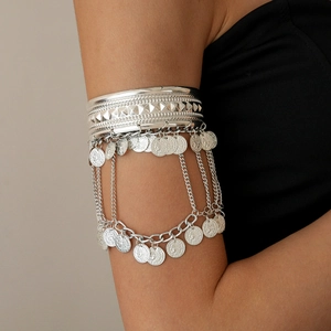 Detail of silver bohemian arm cuff with multi-layer chains and vintage coin charms