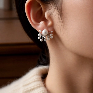 Detailed view of silver pearl fireworks earrings featuring sparkling zircon and starburst design