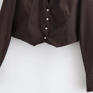 Detail of dark pinstripe blazer hem and cuffs showing white vertical needlework texture