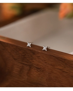 Close-up of S999 sterling silver four-pointed star stud earrings with round zircon