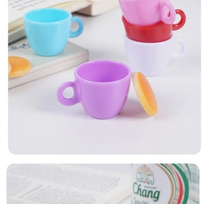 Macro detail of colorful miniature coffee cups and dessert props for dollhouse decor