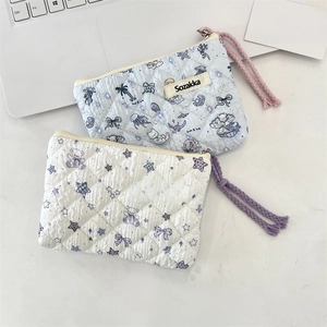 Detail of quilted floral cosmetic bags with Sozakka brand patch and woven rope pullers