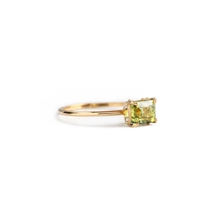 Detail of gold ring with square yellow-green opal and diamond side accents