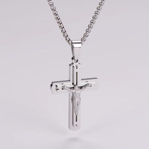 Detailed view of a silver crucifix pendant necklace featuring layered metal textures
