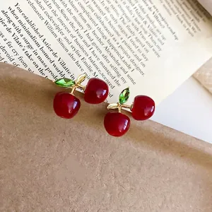 Sweet cherry stud earrings with red resin fruits and gold branches on vintage background