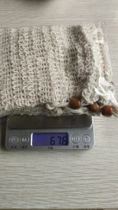 Close-up of a natural cotton soap bag on an electronic scale weighing 67.6 grams