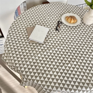 Detailed top view of a round gray and white geometric triangle pattern tablecloth