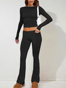 Dettagli del crop top nero a maniche lunghe aderente e dei pantaloni a zampa