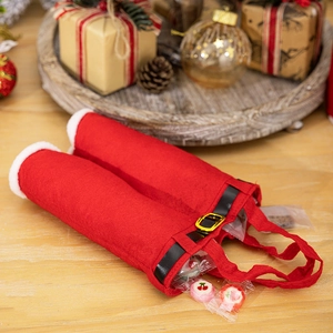 Detail of red Santa pants gift bag with plush trim and belt among festive decor