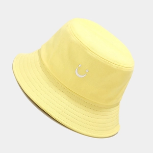 Detail of white smiley face embroidery on yellow canvas sun hat with reinforced stitching