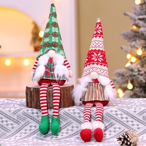 Detail of knitted Christmas gnomes with striped long legs on a festive wooden surface