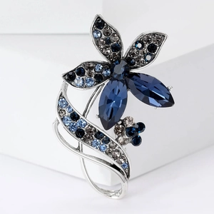 Close-up of elegant flower brooch with sparkling blue rhinestones and silver finish