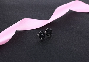 Detailed macro view of black crystal cluster stud earrings with elegant pink ribbon