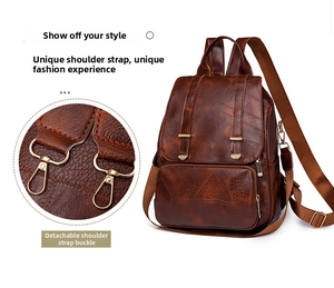 Detailansicht der abnehmbaren goldenen Metallschnalle an einem braunen Vintage-Lederrucksack