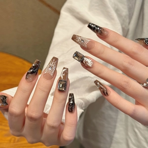 Faux ongles faits main avec motif papillon sombre, effet marbré et cristaux de luxe