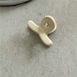 Top view of beige acetate hair claw clip showing polished texture and inner spring