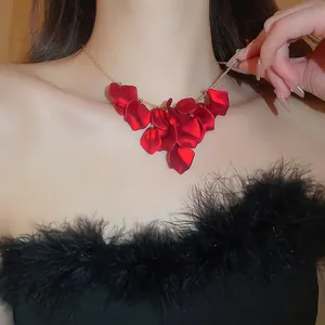 Elegant gold necklace with layered dark red petals and tassels on a fashion model