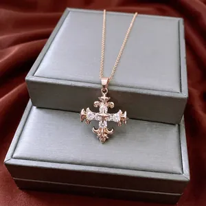 Vintage gold cross necklace with sparkling zircon crystals on a red silk background