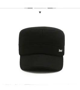Detail of black military flat top hat with a metallic Sport tag on textured wool fabric