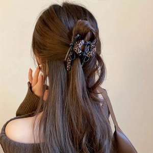Elegant leopard print bow hair claw clip for women shown on long hair from the back view