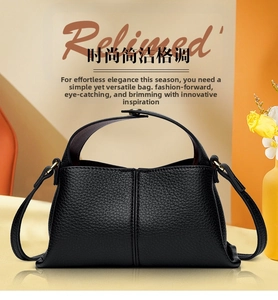 Detailed close-up of a minimalist black litchi pattern leather handbag with metal D-rings
