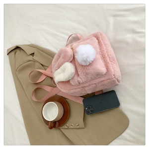Pink lamb wool rabbit ear backpack with cute pom-poms on casual lifestyle background