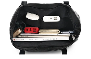 Top-down view of the spacious black tote bag interior showing various daily essentials
