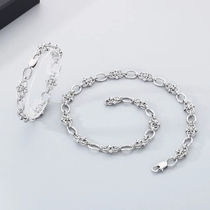 Detail of silver stainless steel chain necklace and bracelet set with intricate link design