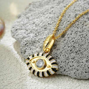 Macro view of 18K gold evil eye pendant with enamel stripes and sparkling cubic zirconia