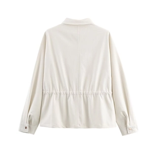 Détail du dos d'une veste blanc cassé montrant la taille élastique et la texture du tissu
