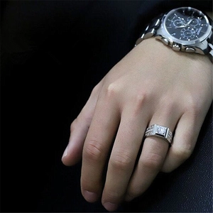 Detailed view of a silver men's ring featuring a central zircon and meander patterns.