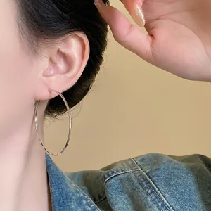 Silver hammered hoop earrings for women with minimalist textured finish on denim