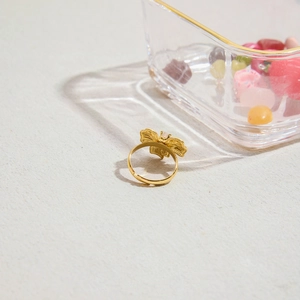 Dettaglio macro di un anello a farfalla dorato con zircone bianco su base ruvida