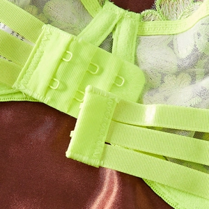 Close-up of three-position back closure on neon green embroidered lace bra set