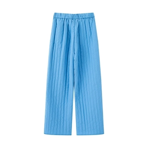 Detail of blue quilted wide-leg pants with elastic waistband and vertical stitching