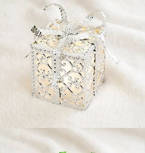 Christmas glowing gift box ornament with silver bow and ornate hollow design for holiday decor.