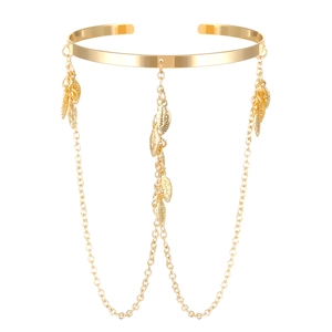 Detail view of golden adjustable arm cuff with three leaf pendant chains and bohemian style