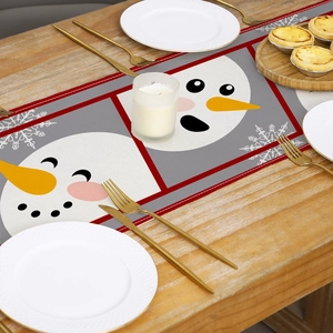 Christmas snowman printed table runner on wooden table with festive dinner setting