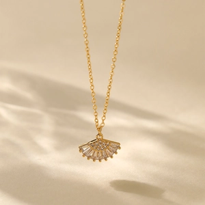 Close-up of fan-shaped pendant with zircons on a gold-plated 18K necklace chain
