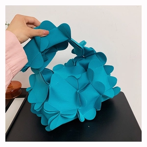 Detail of teal petal shoulder bag with layered 3D floral design and integrated handle