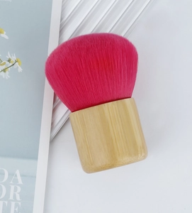 Detail of soft pink mushroom makeup brush head with natural smooth bamboo handle