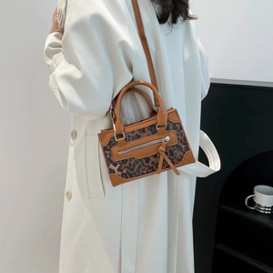 Elegant leopard print mini handbag with brown leather trim shown in a stylish side view