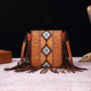 Detail of brown leather crossbody bag with ethnic weaving and long fringe tassels