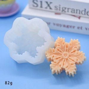 Macro detail of snowflake silicone mold and a finished peach-colored soap casting