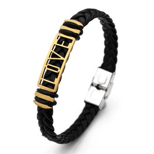 Close-up of black braided leather bracelet with golden LOVE charm and silver metal clasp