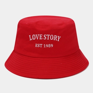 Detail of red bucket hat featuring white Love Story embroidery and cotton twill texture
