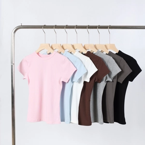 Row of colorful modal t-shirts on wooden hangers showing seven vibrant fabric colors