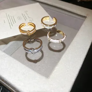 18k gold plated crisscross adjustable ring with white enamel and zircon accents