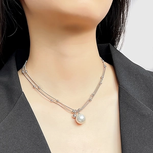 Close-up of double-layer silver bead chain necklace with round white pearl pendant
